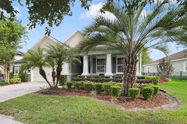 view of front of property featuring fence, an attached garage, a front lawn, a porch, and driveway
