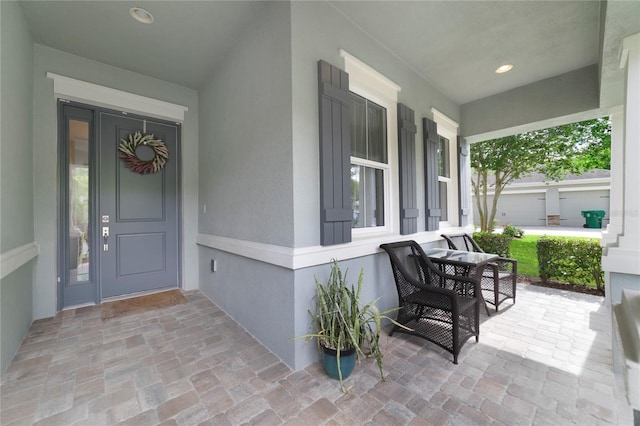 property entrance with stucco siding and covered porch