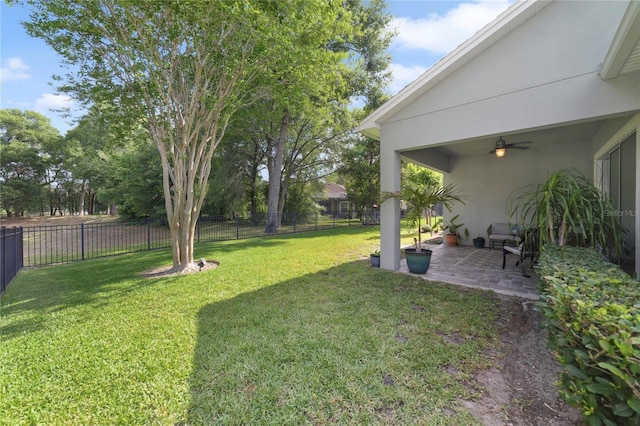 view of yard featuring a fenced backyard, a ceiling fan, and a patio area