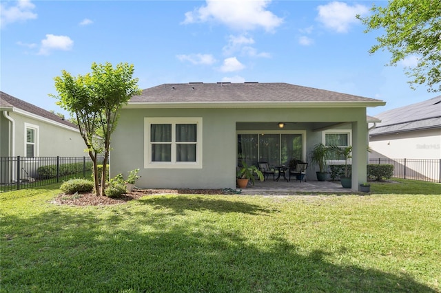back of house featuring a lawn, a fenced backyard, a patio area, and stucco siding
