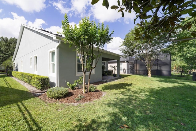 back of property with a yard, fence, and stucco siding