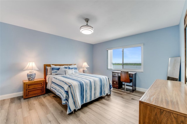 bedroom featuring baseboards and light wood-style flooring