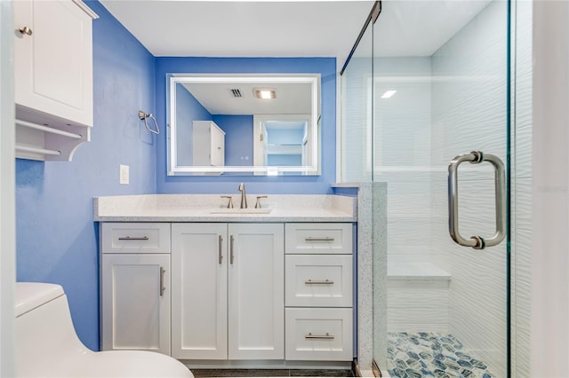 bathroom featuring vanity, a shower stall, toilet, and visible vents