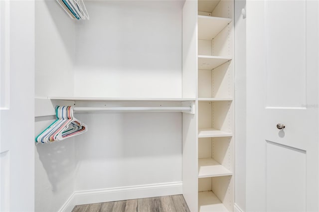 walk in closet with wood finished floors