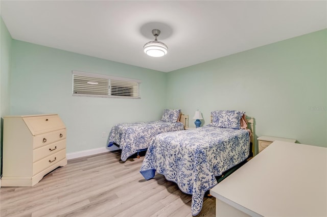 bedroom with baseboards and light wood-type flooring