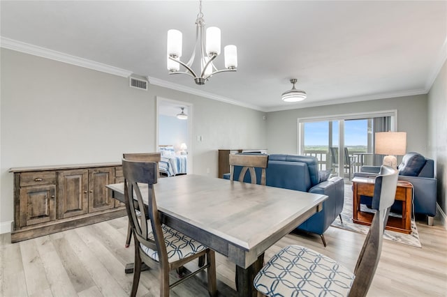 dining area featuring visible vents, baseboards, a notable chandelier, ornamental molding, and light wood-style flooring