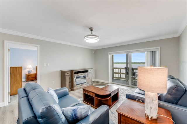 living room featuring a water view, baseboards, ornamental molding, and light wood-style floors