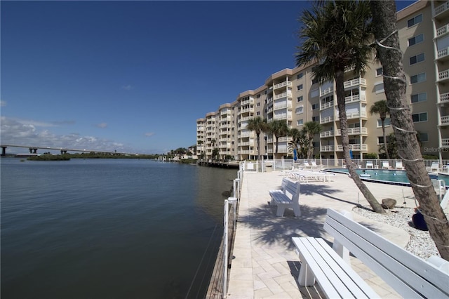dock area featuring a water view and a community pool