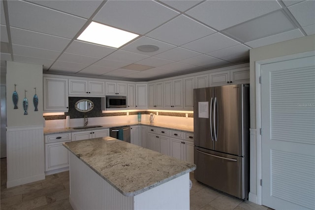 kitchen with a sink, appliances with stainless steel finishes, and white cabinetry
