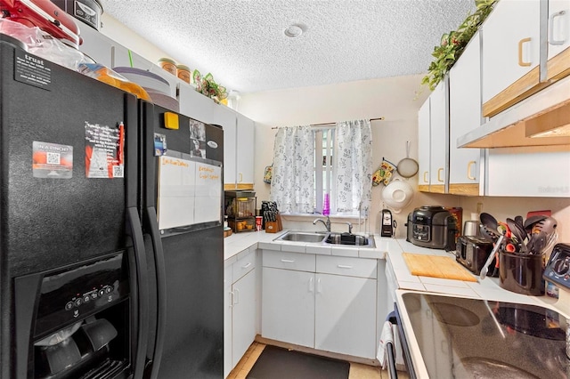 313 Dirksen Dr Unit A5, Debary, FL 32713 - kitchen featuring tile countertops, a sink, electric range oven, black fridge with ice dispenser, and a textured ceiling