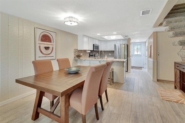 dining area with baseboards, recessed lighting, light wood finished floors, and visible vents