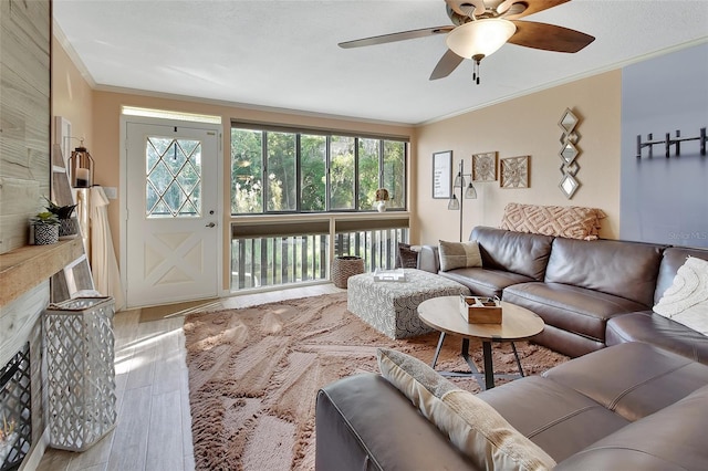 living room with ornamental molding, a ceiling fan, and wood finished floors