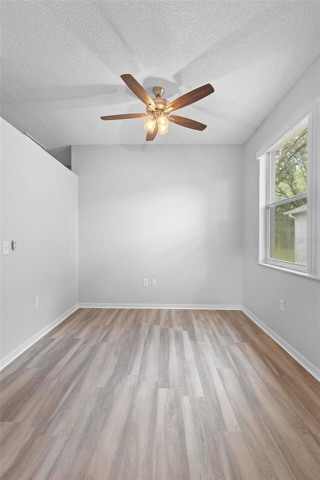15733 Green Point Ct, Clermont, FL 34714 - spare room with baseboards, ceiling fan, a textured ceiling, and wood finished floors