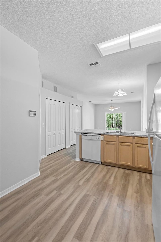15733 Green Point Ct, Clermont, FL 34714 - kitchen featuring a textured ceiling, white appliances, visible vents, a sink, and light wood-style floors