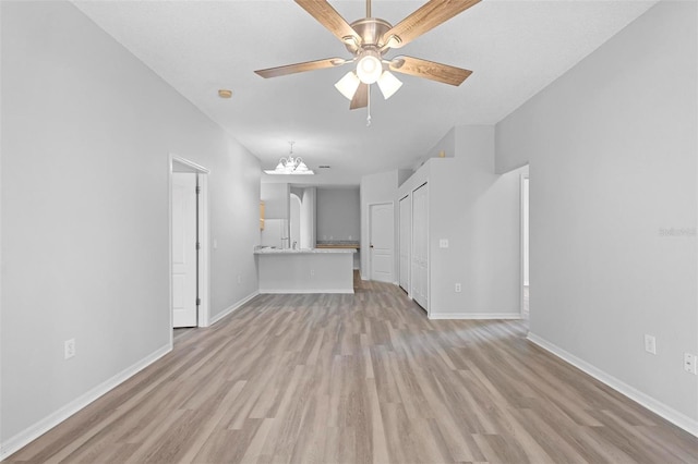 15733 Green Point Ct, Clermont, FL 34714 - unfurnished living room with ceiling fan with notable chandelier, baseboards, and light wood-style floors