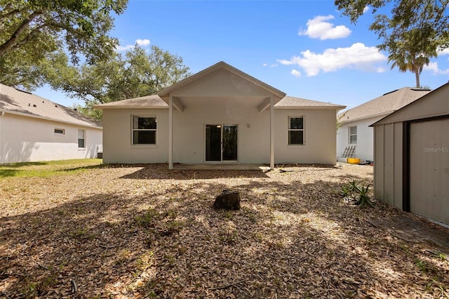 15733 Green Point Ct, Clermont, FL 34714 - rear view of property featuring an outdoor structure, stucco siding, and a storage shed