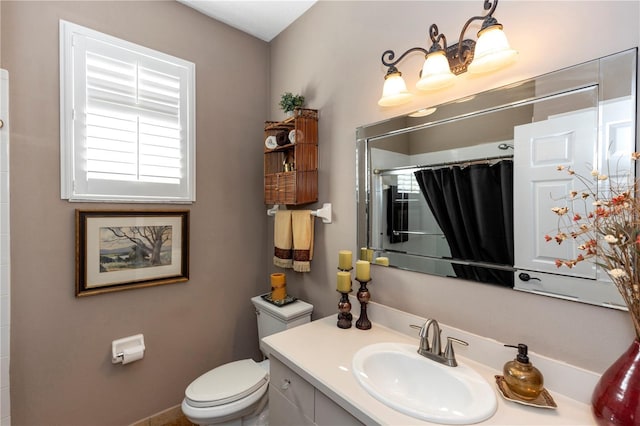 bathroom with toilet, curtained shower, and vanity