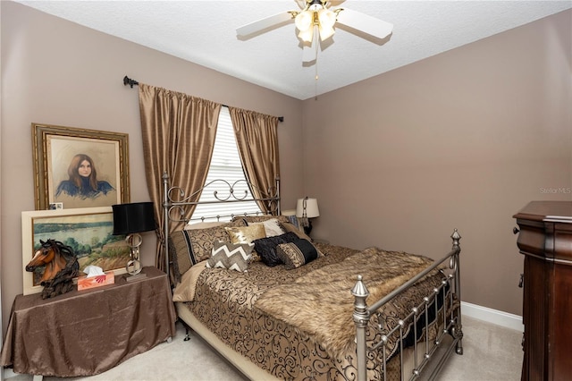 bedroom featuring light colored carpet, baseboards, and ceiling fan