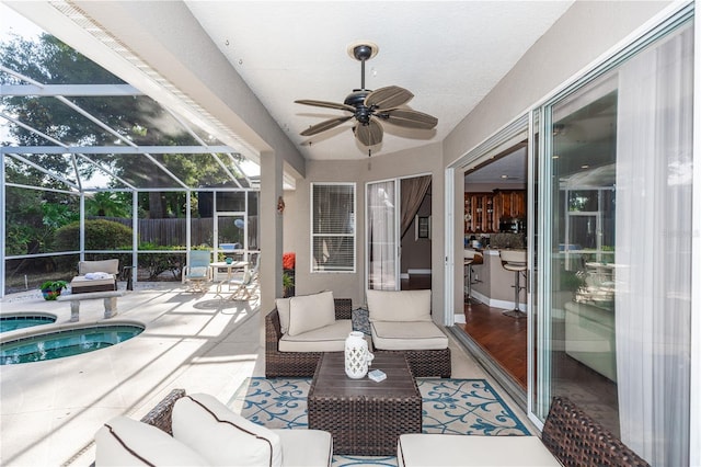 sunroom / solarium featuring ceiling fan and a jacuzzi