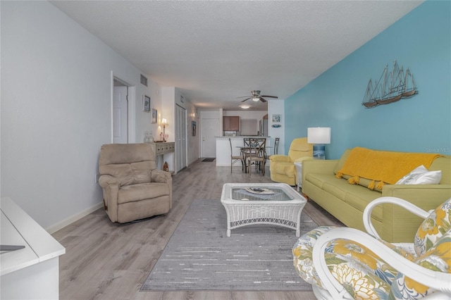 2711 N Halifax Ave Unit 496, Daytona Beach, FL 32118 - living area featuring a ceiling fan, light wood-type flooring, baseboards, and a textured ceiling