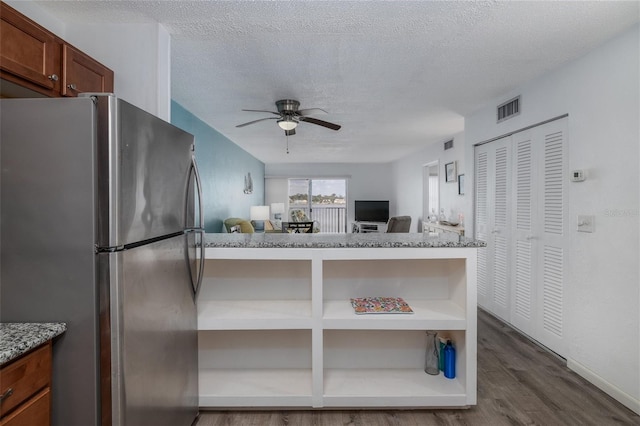 2711 N Halifax Ave Unit 496, Daytona Beach, FL 32118 - kitchen featuring freestanding refrigerator, dark wood-type flooring, a ceiling fan, open floor plan, and a textured ceiling