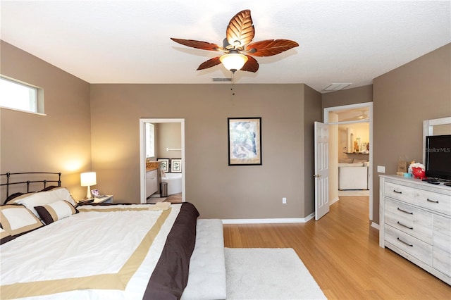bedroom featuring visible vents, light wood finished floors, ensuite bathroom, and baseboards
