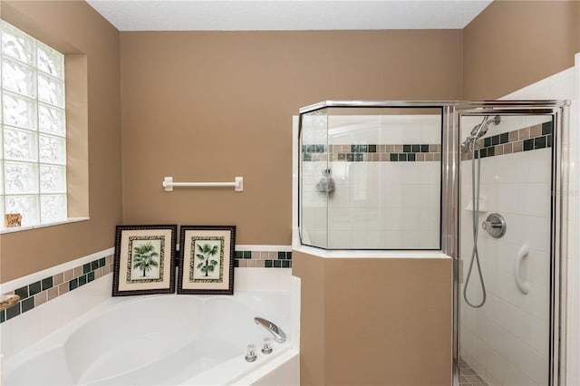 bathroom with a shower stall, a bath, and a wealth of natural light