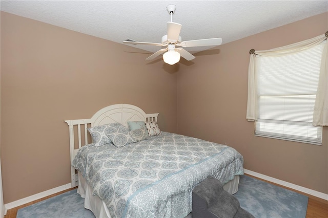 bedroom featuring baseboards, a ceiling fan, and wood finished floors