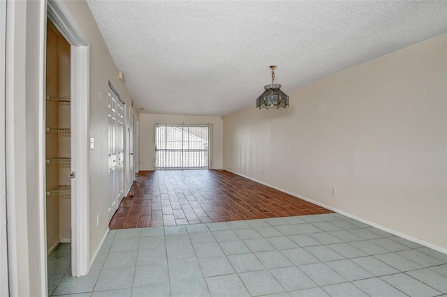 313 Dirksen Dr Unit B15, Debary, FL 32713 - empty room featuring a textured ceiling, baseboards, and tile patterned flooring