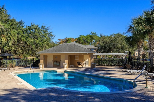 pool with a patio and fence