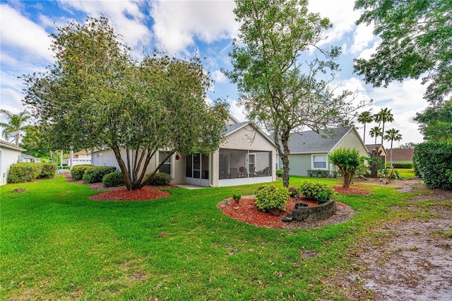 276 Gala Cir, Daytona Beach, FL 32124 - rear view of property with a sunroom, a lawn, and stucco siding