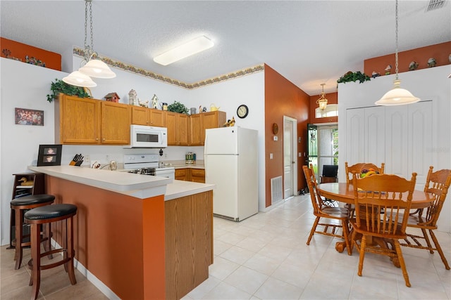 276 Gala Cir, Daytona Beach, FL 32124 - kitchen featuring white appliances, a peninsula, hanging light fixtures, brown cabinets, and a textured ceiling