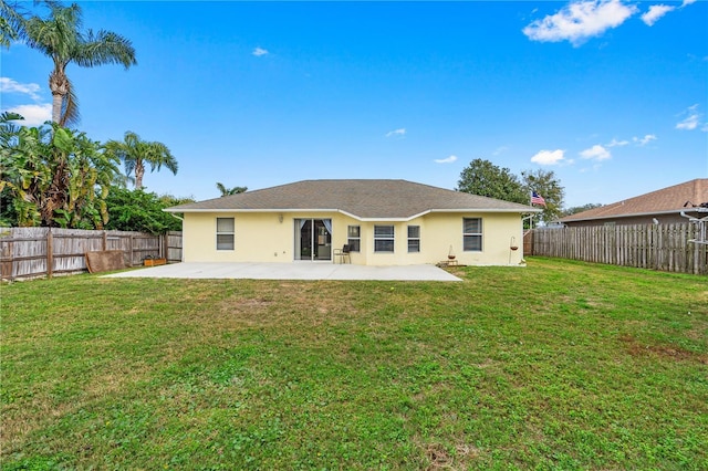 rear view of house featuring a lawn, a fenced backyard, and a patio area