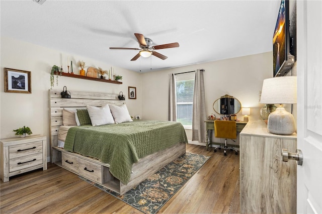 bedroom with ceiling fan and dark wood-style floors