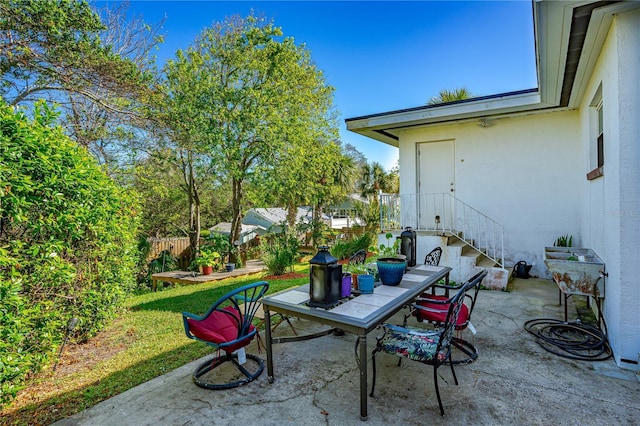 view of patio with outdoor dining area and fence