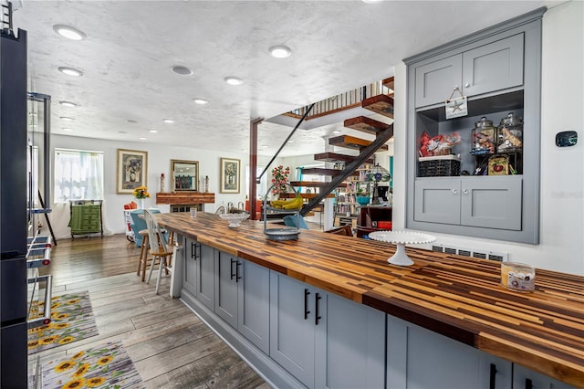 bar with wood finished floors and stairway