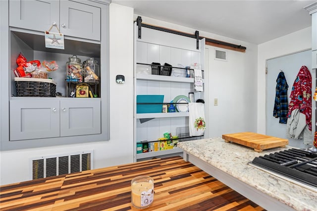 mudroom with a barn door and visible vents