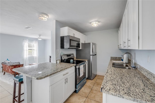 128 Oakridge Ave, Edgewater, FL 32132 - kitchen featuring visible vents, a sink, light tile patterned floors, a breakfast bar, and stainless steel appliances