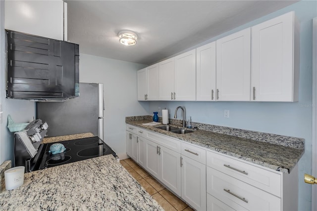 128 Oakridge Ave, Edgewater, FL 32132 - kitchen with freestanding refrigerator, light tile patterned flooring, stainless steel electric range, white cabinets, and a sink