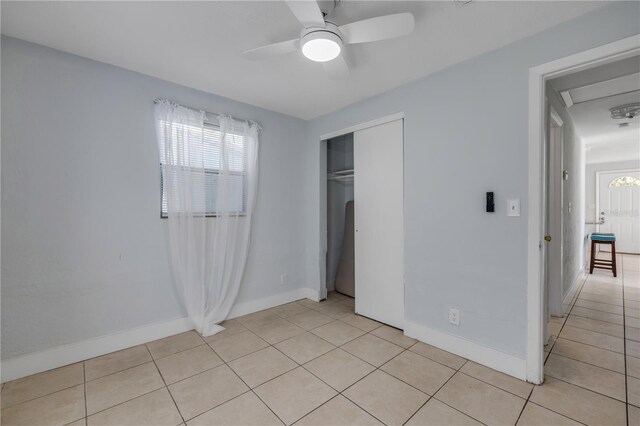 128 Oakridge Ave, Edgewater, FL 32132 - unfurnished bedroom with baseboards, ceiling fan, light tile patterned floors, and a closet