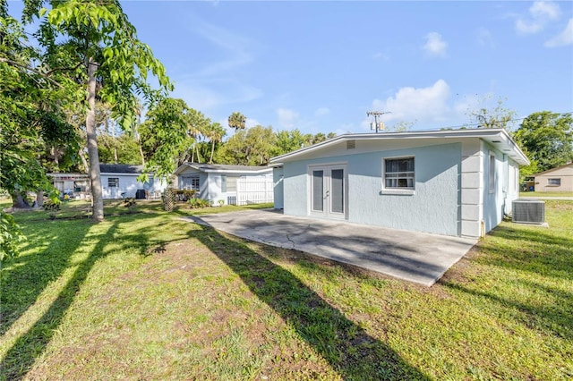 128 Oakridge Ave, Edgewater, FL 32132 - rear view of house with french doors, a patio, a lawn, and central air condition unit