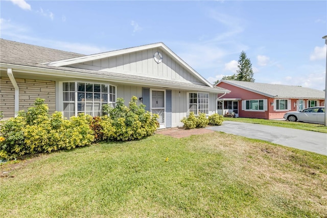 ranch-style house featuring board and batten siding and a front lawn