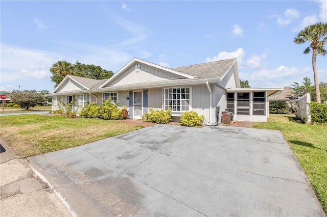 single story home featuring a sunroom and a front lawn