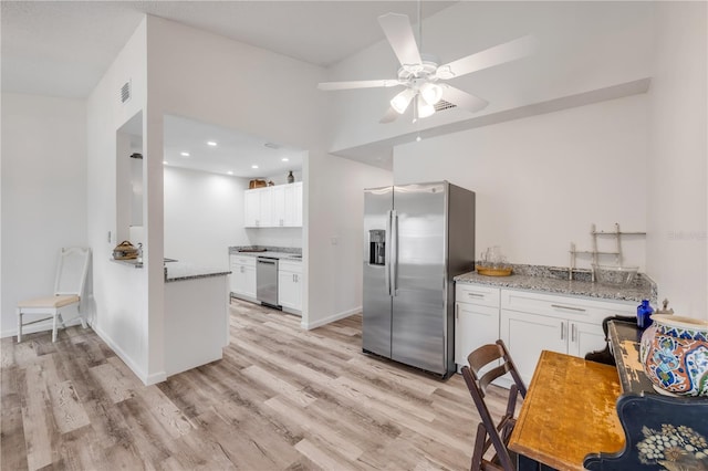 kitchen with light stone countertops, light wood-type flooring, white cabinetry, a ceiling fan, and stainless steel appliances