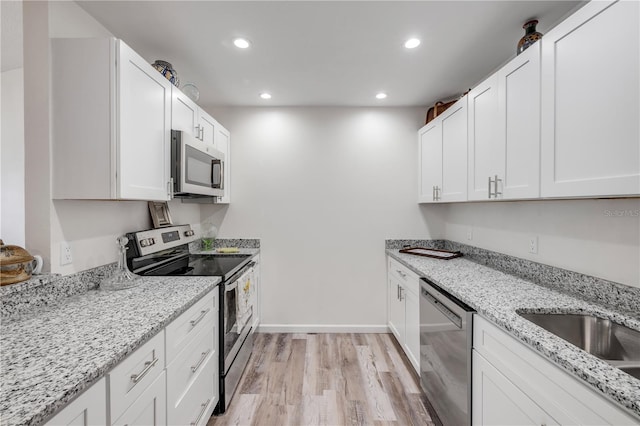 kitchen featuring light wood-type flooring, recessed lighting, appliances with stainless steel finishes, and white cabinets