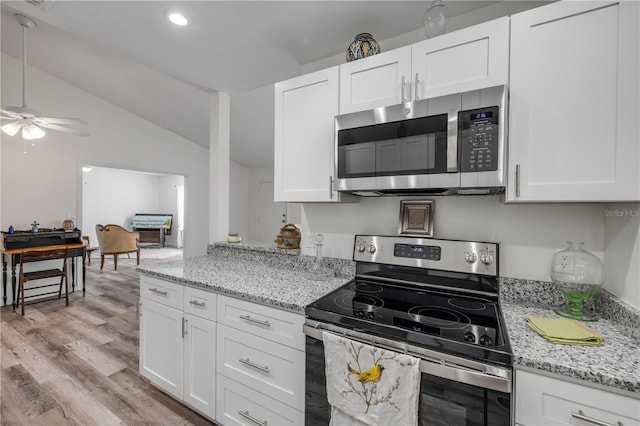 kitchen featuring stainless steel appliances, a ceiling fan, white cabinetry, and lofted ceiling