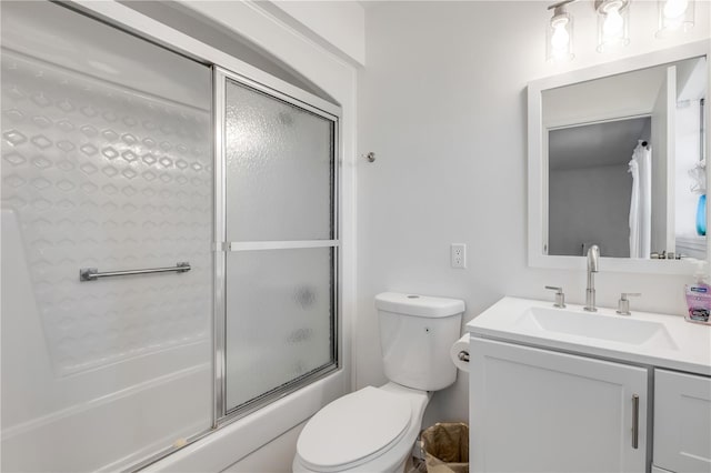 bathroom featuring vanity, toilet, and shower / bath combination with glass door