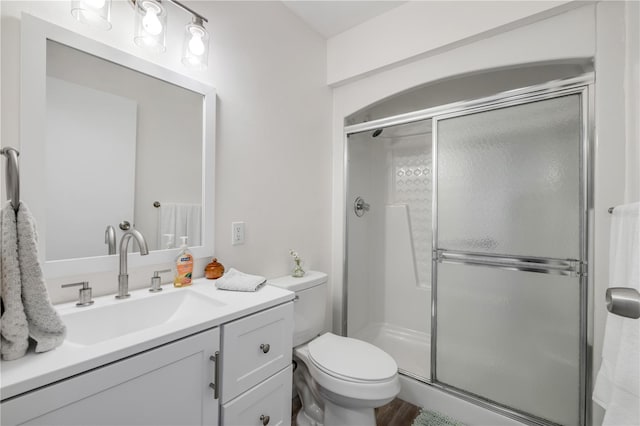 full bath featuring vanity, toilet, and a shower stall