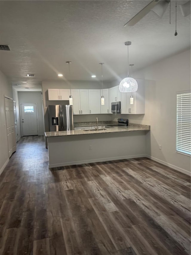 926 Clover St, Deland, FL 32720 - kitchen with a peninsula, baseboards, dark wood-type flooring, a sink, and appliances with stainless steel finishes