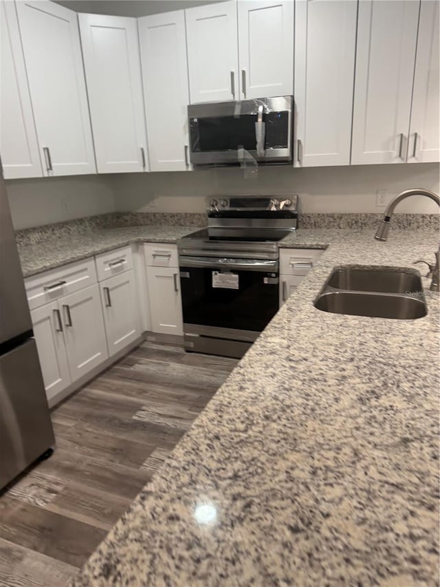 926 Clover St, Deland, FL 32720 - kitchen with stainless steel appliances, dark wood finished floors, white cabinetry, and a sink